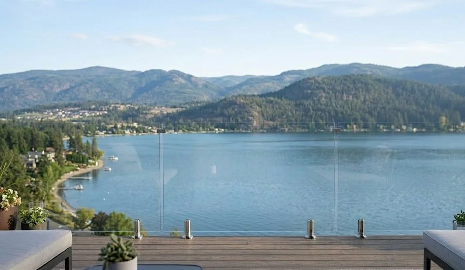 Frameless glass deck railing with stainless steel spigot mounts on composite deck overlooking Okanagan lake