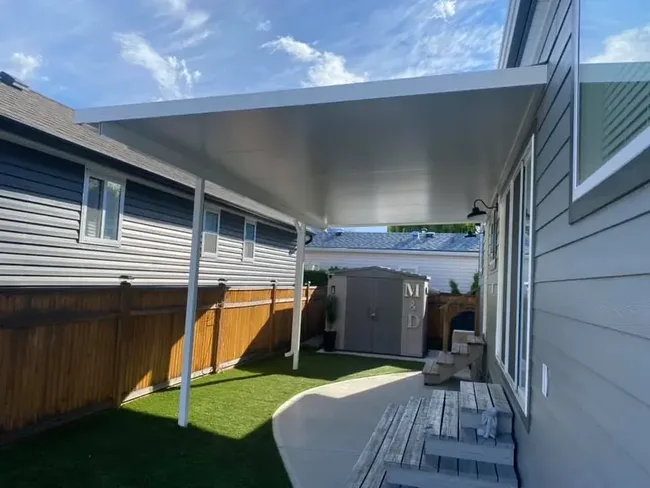 White aluminum patio cover over a backyard patio in Kelowna